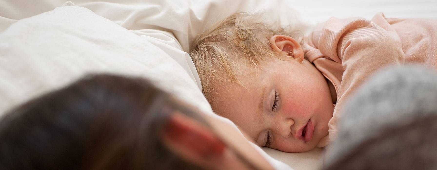 Sovande bebis med mamma