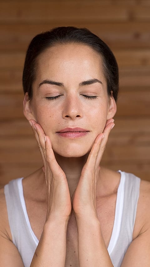 ​​​​​​​Kvinna smörjer in sig med Granatäpple Firming Facial Oil