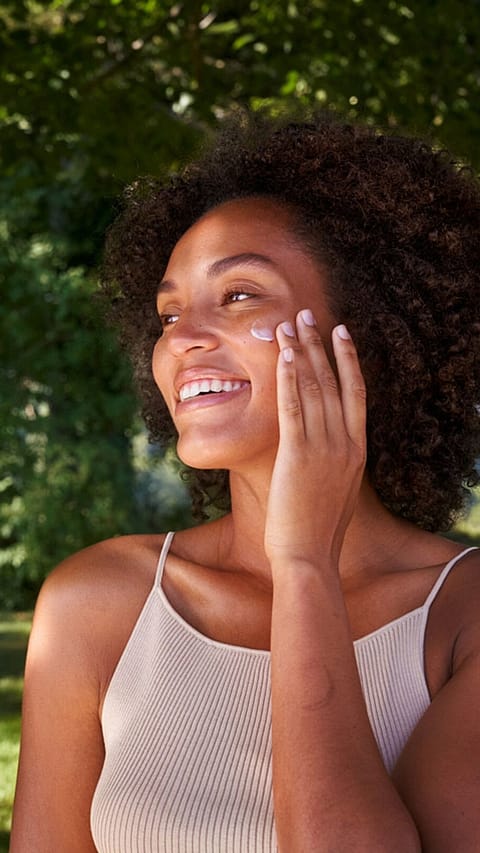 Kvinna smörjer in sig med Weleda Skin Food ansiktskräm