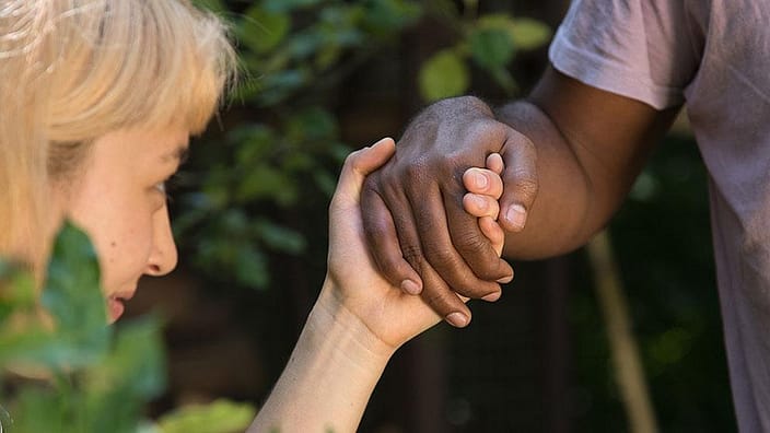 personer håller hand i närbild