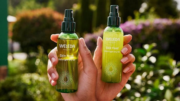 Hand som visar upp Weleda skin food dry oil
