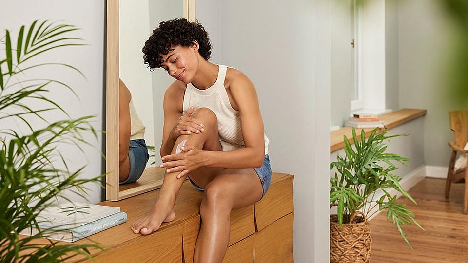 Woman creaming legs