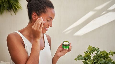 Kvinna smörjer in sig med Skin Food hudkräm