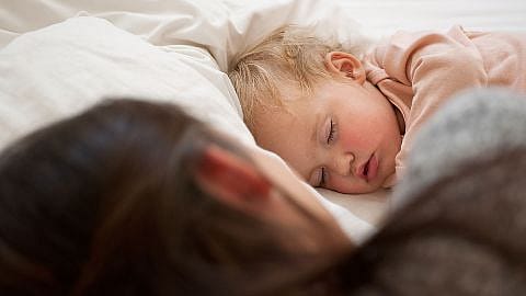 Sovande bebis med mamma