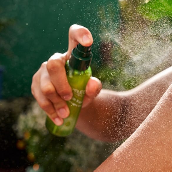 Kvinna sprayar Weleda dry oil på armen
