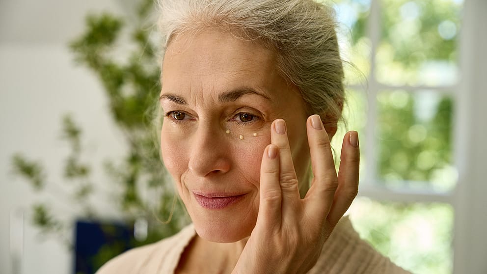 Kvinna smörjer sig med Weleda Contouring Eye & Lip Cream