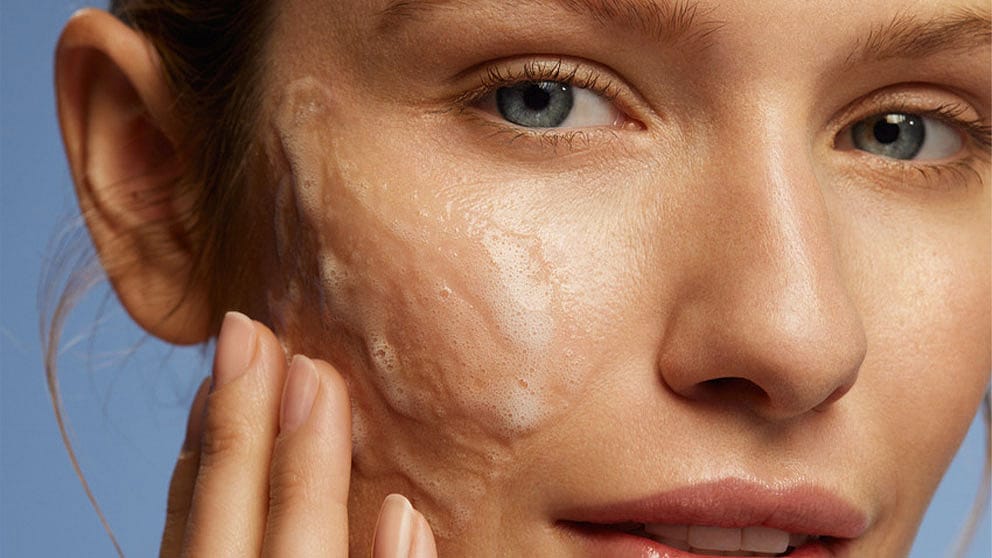 Kvinna tvättar ansiktet med Weleda - Deep Cleansing Gel