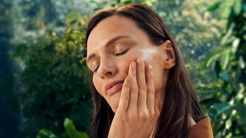 kvinna smörjer in ansiktet med Weleda Firming Day Cream