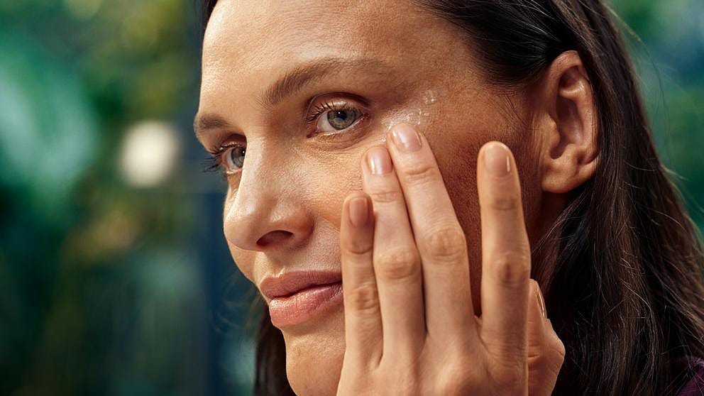 Kvinna smörjer sig med Weleda Firming Eye Cream